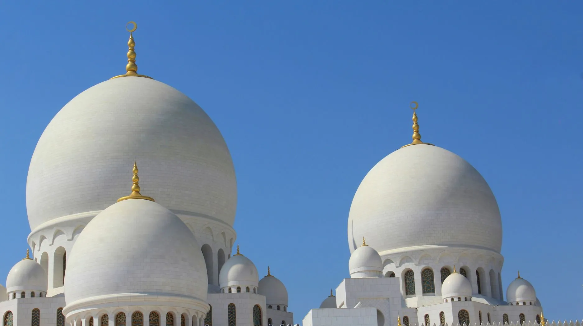 Abu Dhabi, Émirats Arabes Unis — majestueuses coupoles blanches sous un ciel bleu éclatant.