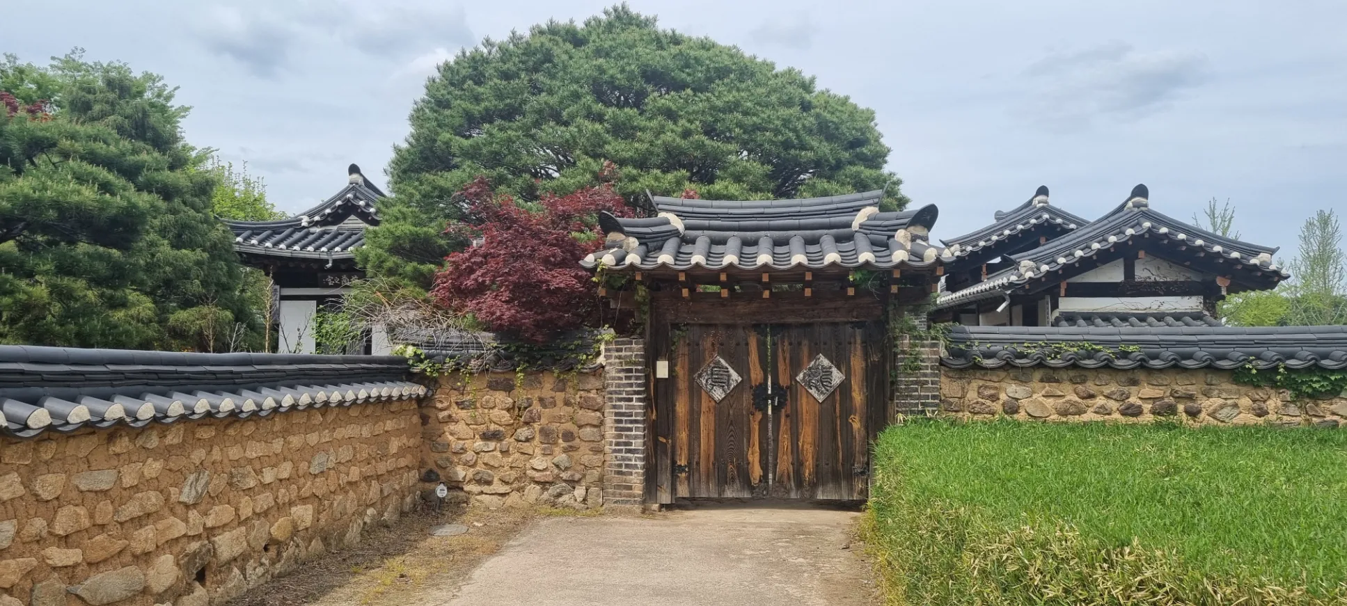 Portail en bois et maisons traditionnelles, Corée du Sud — un cadre historique et paisible.