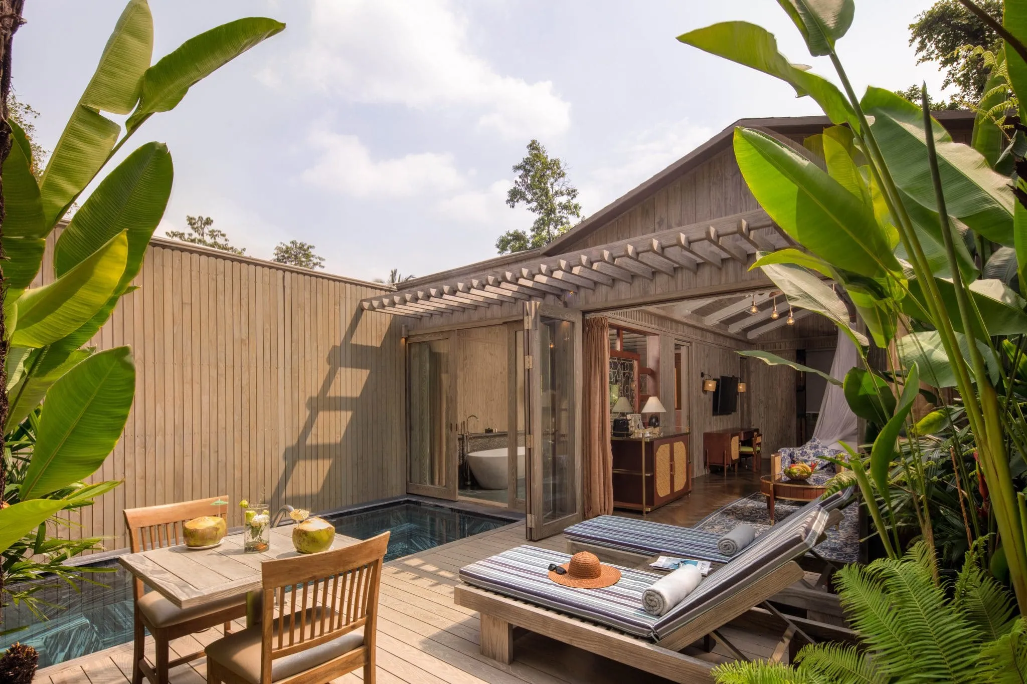 Espace paisible avec piscine et végétation luxuriante, idéal pour une escapade relaxante.
