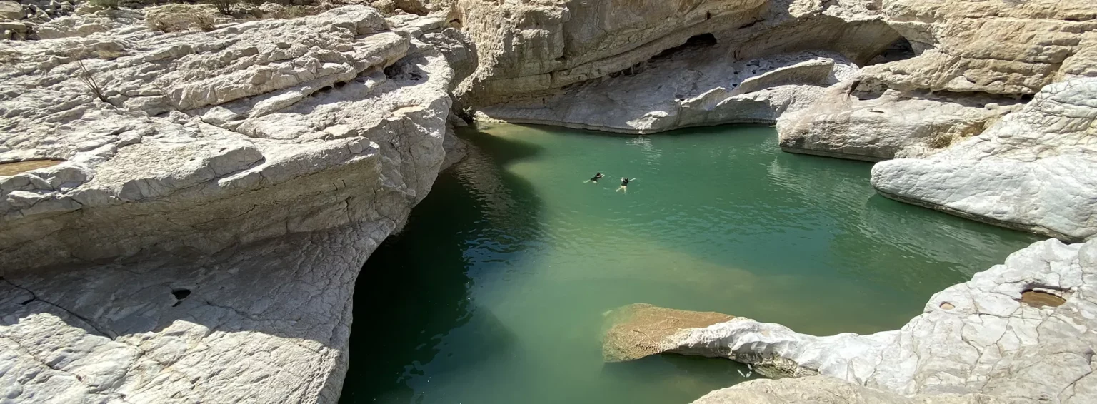Eau turquoise entourée de rochers majestueux, un lieu paisible pour se ressourcer.