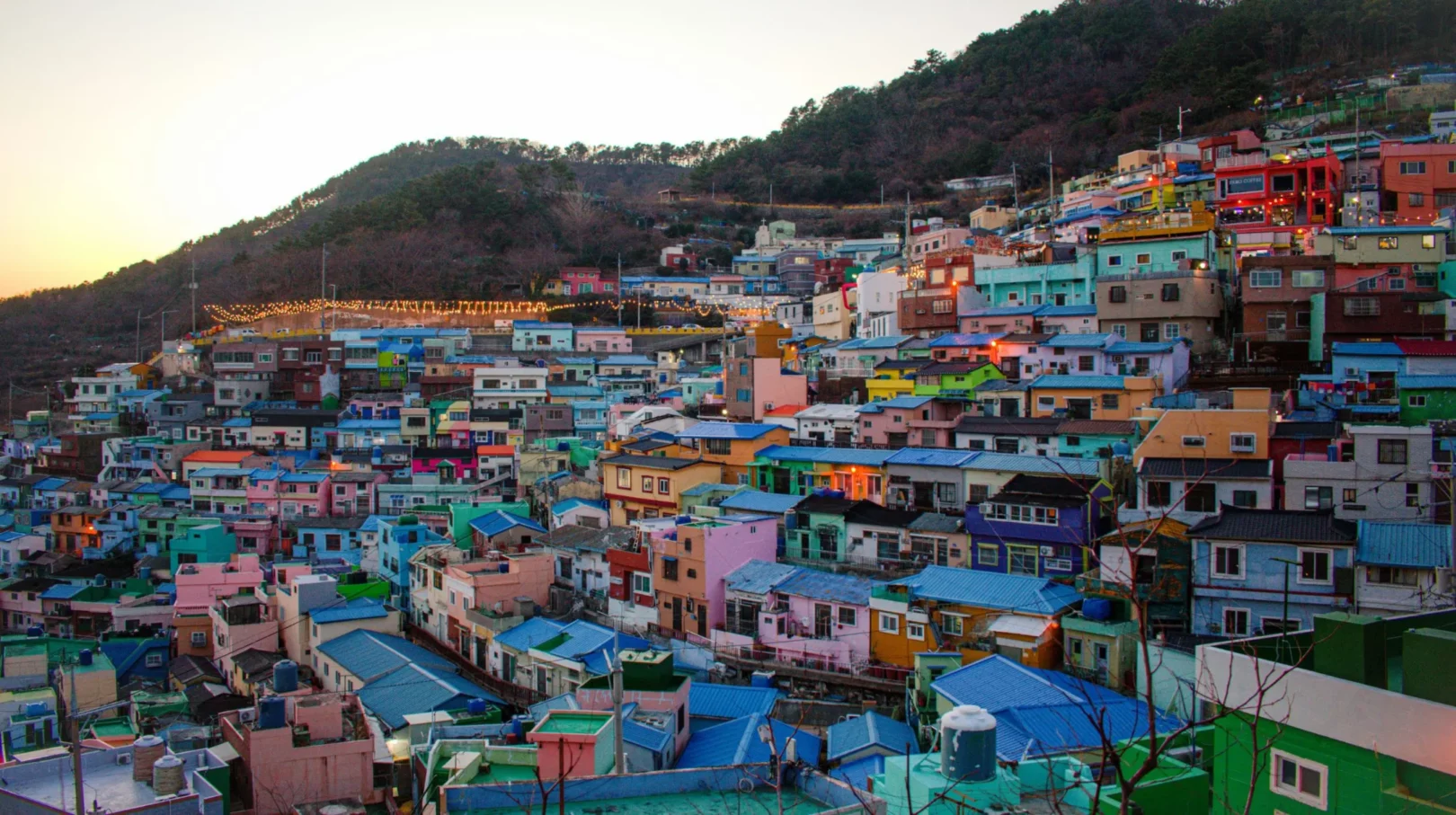 Quartier coloré, Corée du Sud — maisons pittoresques s'élevant sur une colline à la tombée de la nuit.