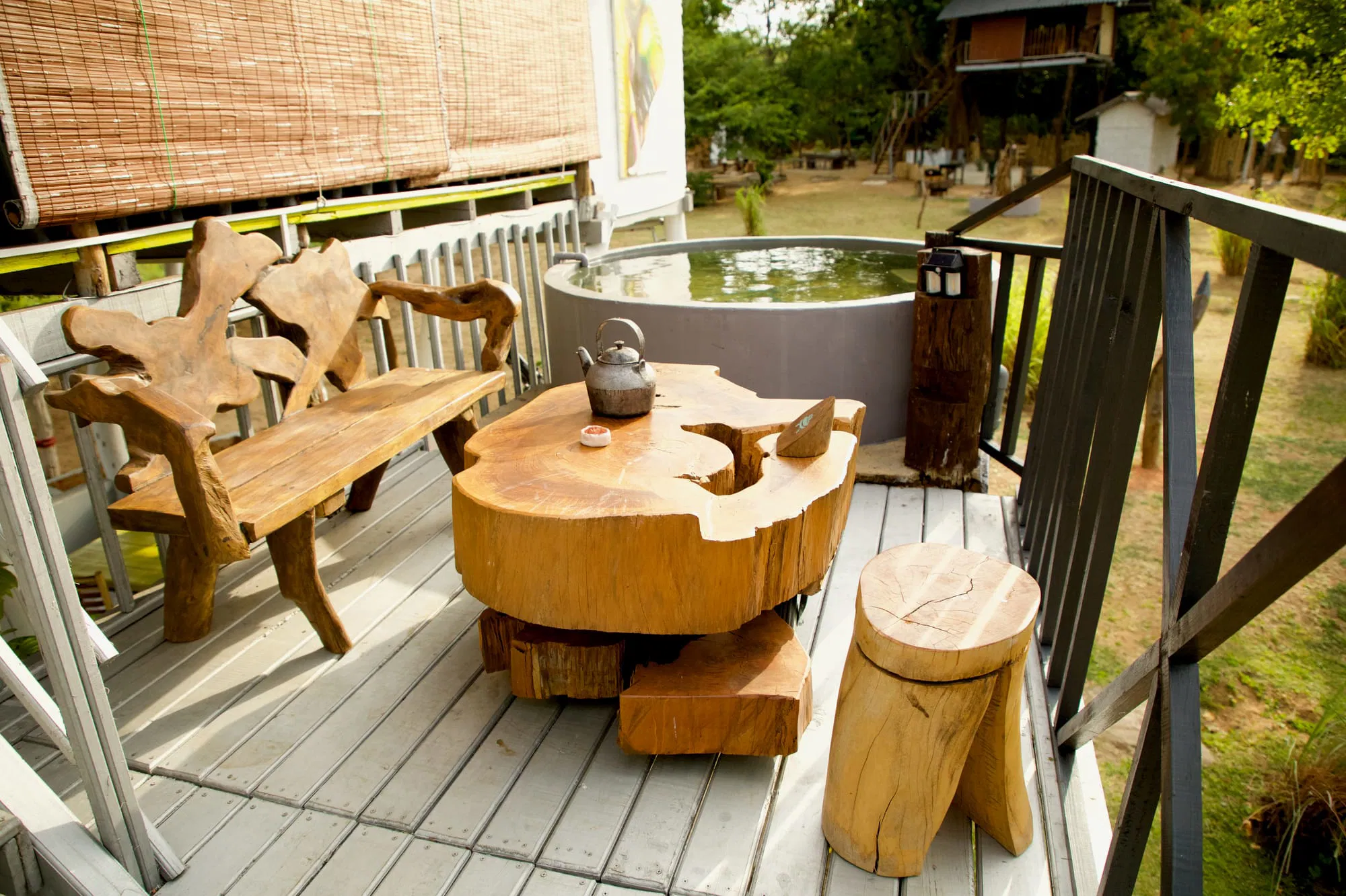 Espace extérieur charmant avec mobilier en bois, idéal pour se détendre dans un cadre paisible et naturel.