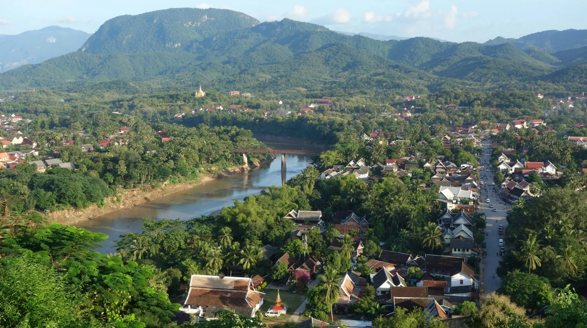 Luang Prabang, Laos — vue panoramique sur les montagnes et la rivière, entourée de maisons pittoresques et de verdure luxuriante.
