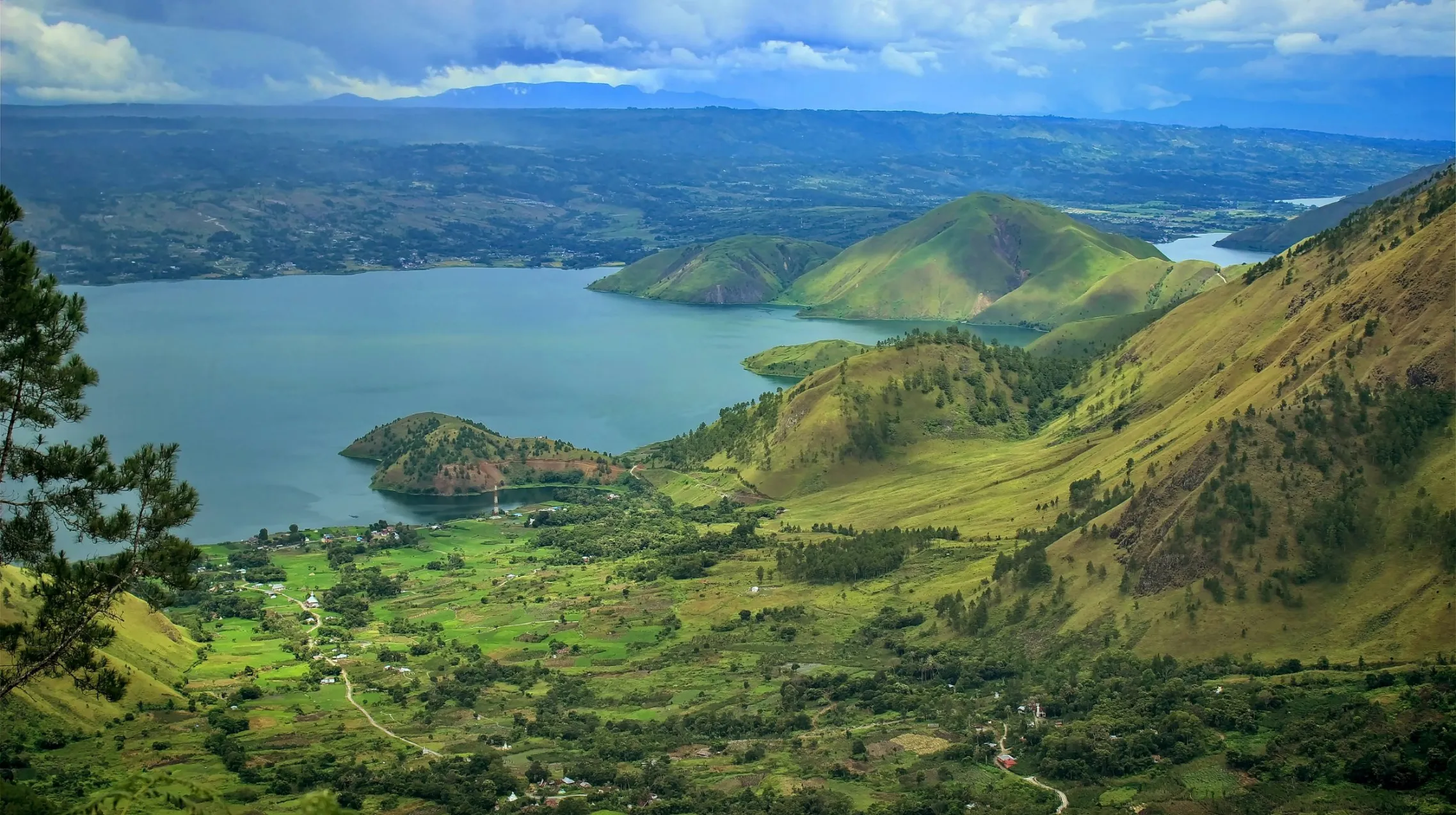 Paysage verdoyant et lac paisible, offrant une vue spectaculaire sur les collines environnantes.