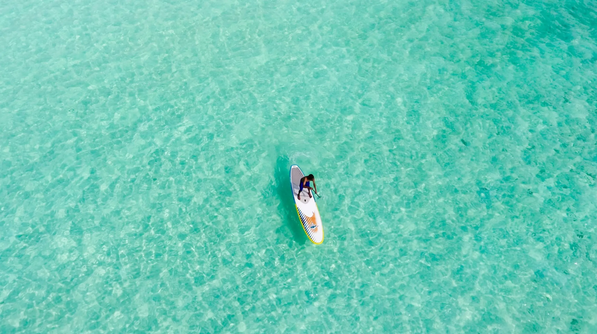 Paddleboard sur des eaux turquoise, ambiance paisible et tropicale.
