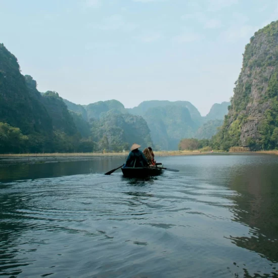 Naviguer paisiblement sur les eaux d'un paysage époustouflant, entouré de montagnes verdoyantes et mystérieuses.