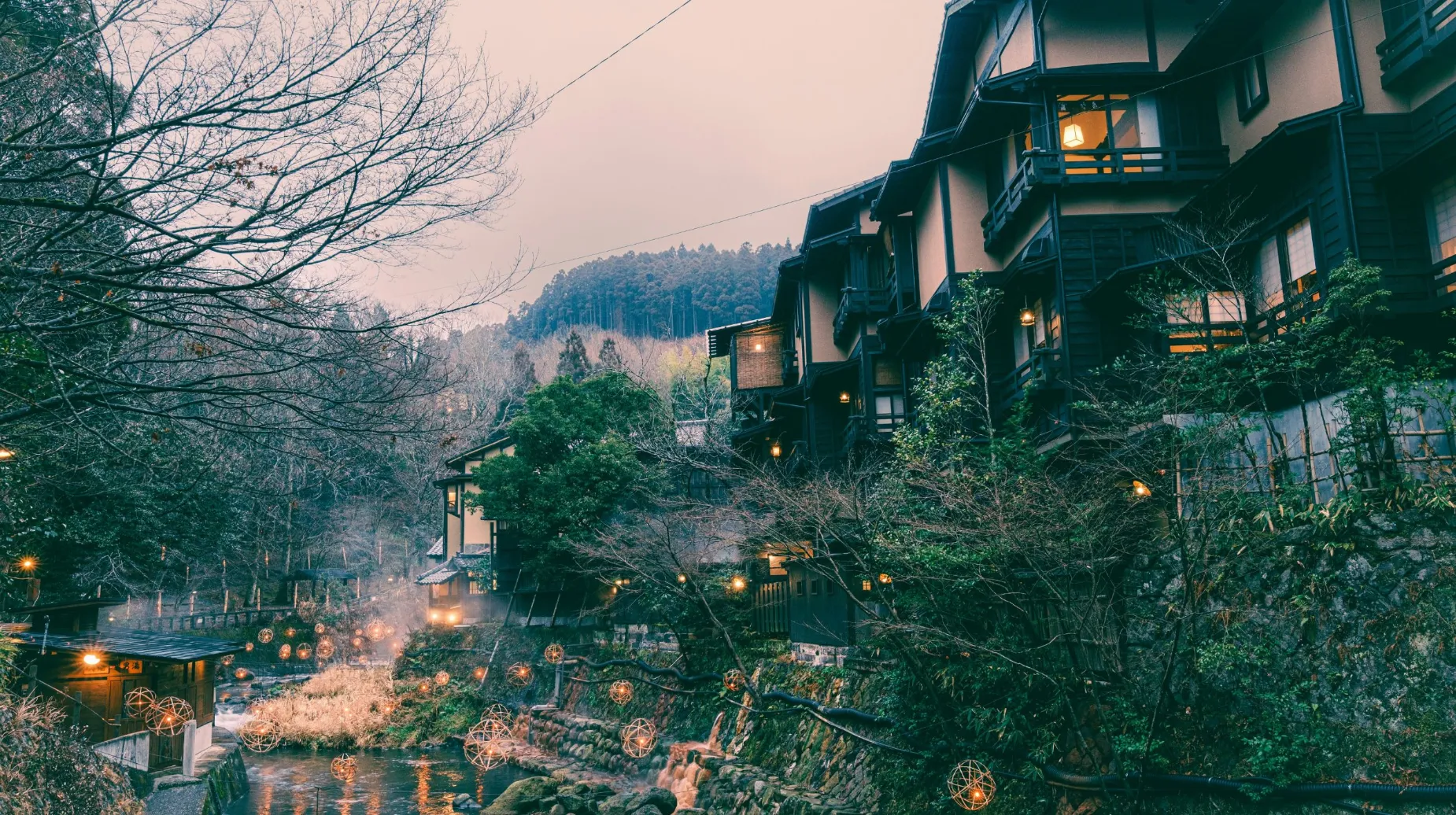 Village traditionnel au Japon — ambiance paisible au bord d'une rivière, entouré de nature et de lanternes.